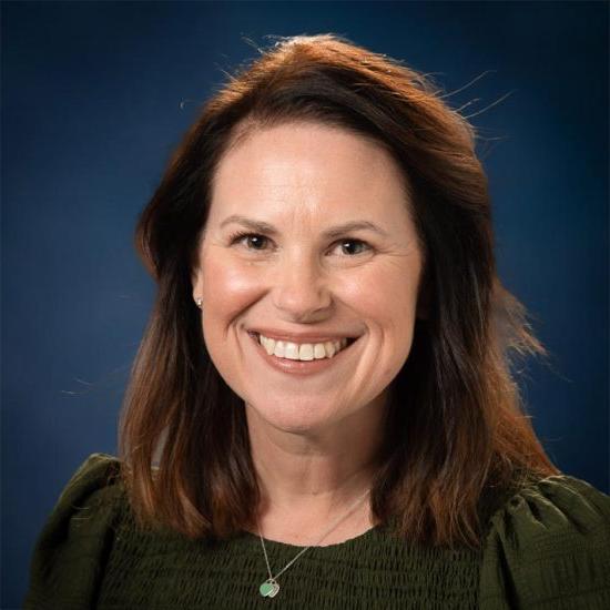 Headshot of Kathryn Dixon, a woman with white skin and long red hair.